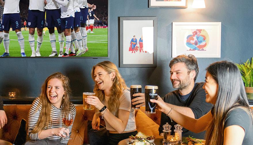 A group of people enjoying a pint watching the football