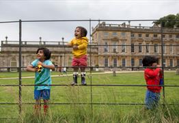 Children playing in front of a historic house
