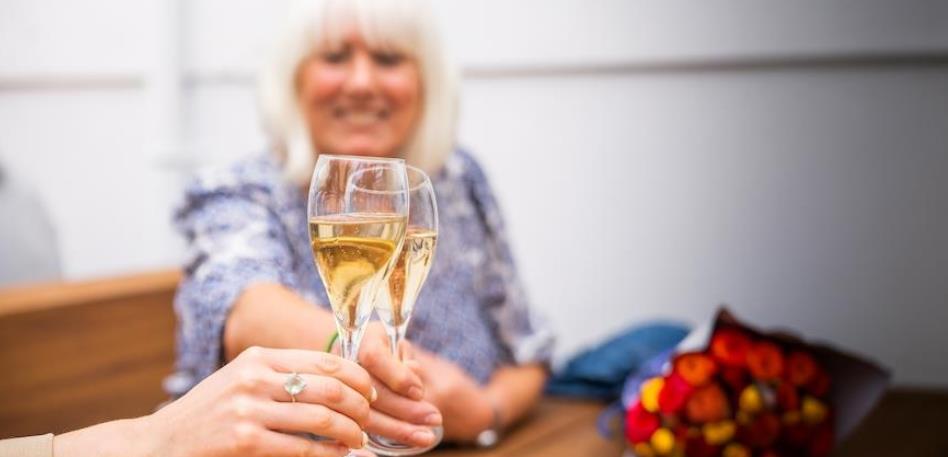 Person toasting glass of fizz
