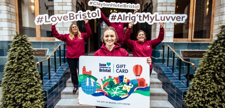 Clayton Hotel staff in Bristol holding up a LoveBristol Gift Card outside the hotel