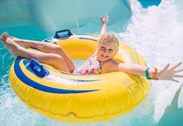 Child on rubber dingy water slide