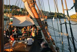 Band called Piratitude perform on The Matthew ship in Bristol Harbour with audience looking on