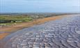 Looking down on the sandy Brean beach as waves lap the shoreline