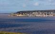 Looking across a bay to Weston-super-Mare town with woods behind