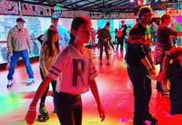People skating at roller disco with multi coloured lights