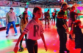 People skating at roller disco with multi coloured lights