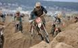 Motorbike riders battle on a sand made obstacle course during a beach race