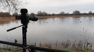 A camera on a tripod next to a lake 