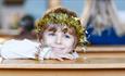 A young boy wearing a gold tinsel crown