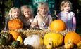 Children stood behind pumpkins