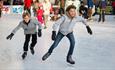 Two boys in grey jackets ice skating