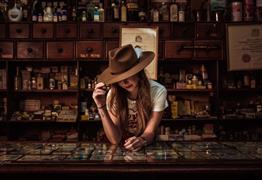 Demi Marriner stood up against a bar wearing a cowboy hat