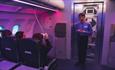 People sat on mock plane in purple light