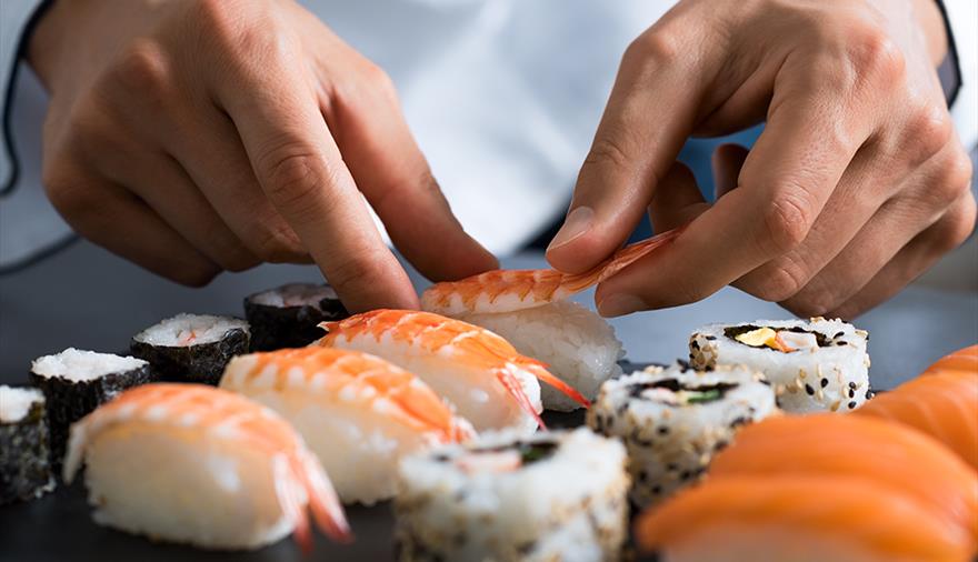 Close up of hands making sushi