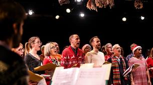 Group in Christmas jumpers singing