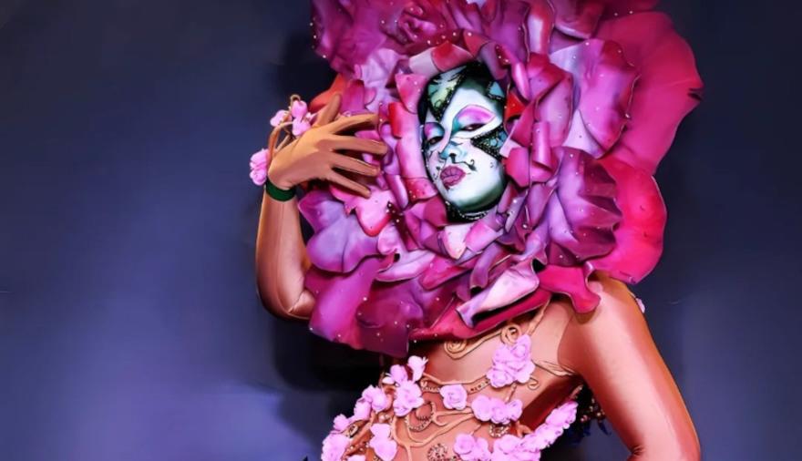 A drag artist with a flower head dress