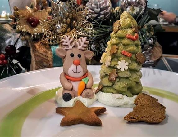 a festive dessert which features gingerbread biscuits and desserts shaped as a reindeer and a christmas tree