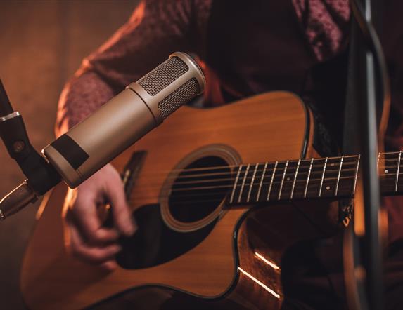 close up of acoustic guitar and microphone