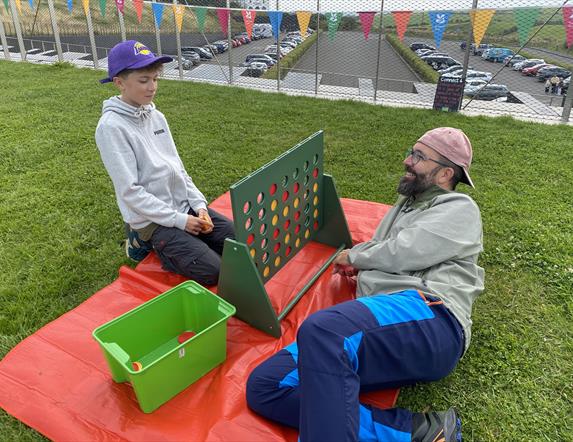 Two visitors enjoying a game of GIANT Connect 4 on the roof of the Giant's Causeway Visitor Centre