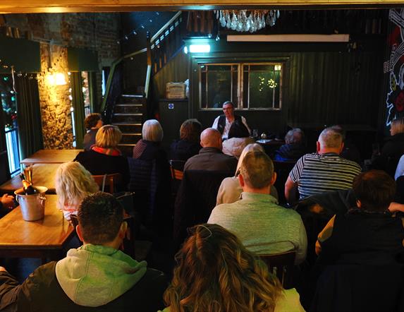 people gathered inside a bar as part of a tour group