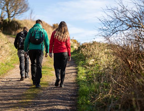 people walk on a rural hiking trail