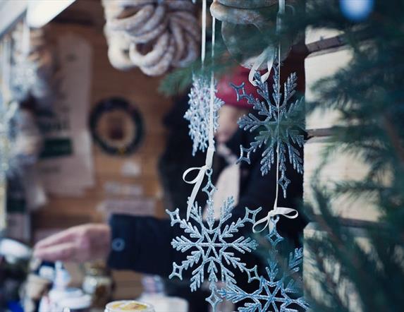 decorative snowflakes hang from a market stall