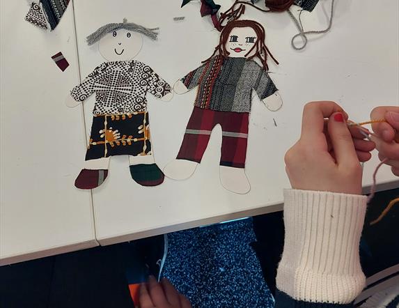 Small cutouts of little people, made from textiles like wool and linen.