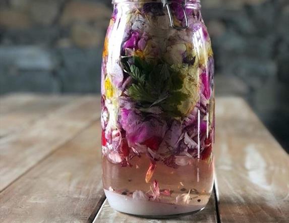 Jar filled with naturally infused gin, containing  beautiful, colourful ingredients
