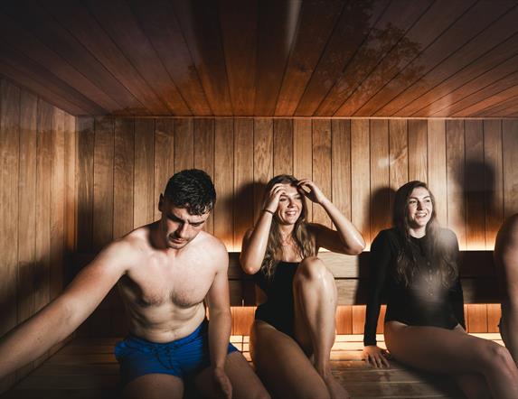 4 people relax in a sauna