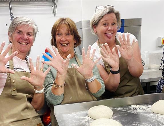 women cooking sourdough with flour all over their hands