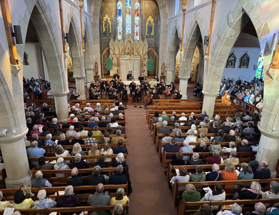 The ulster orchestra performs in the hall of St. Patrick's and St. Brigid's church.