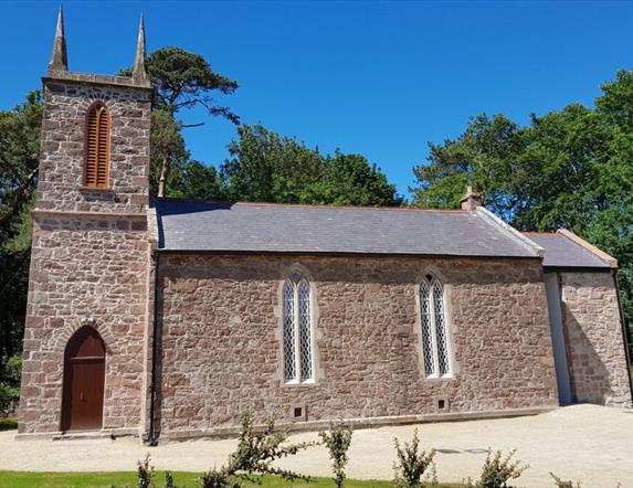 Old stone church building with blue sky beyond