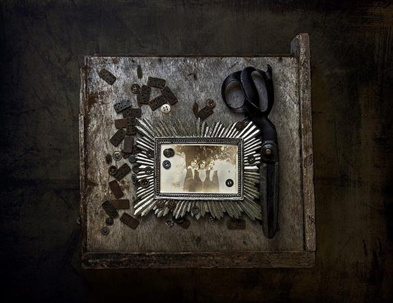 An old fashioned photograph in a silver frame, against a dark background.