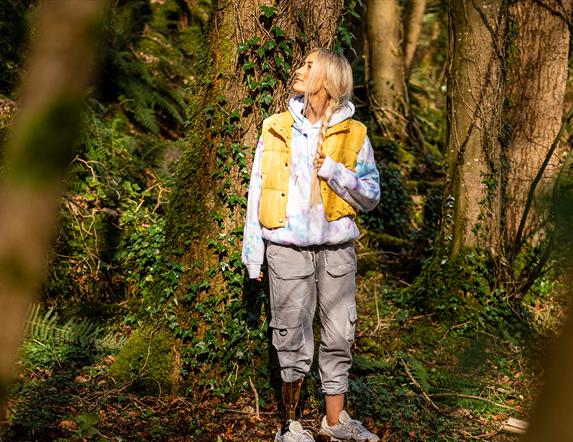 Girl standing pensively beside a tree as part of the Mussenden Unwind experience