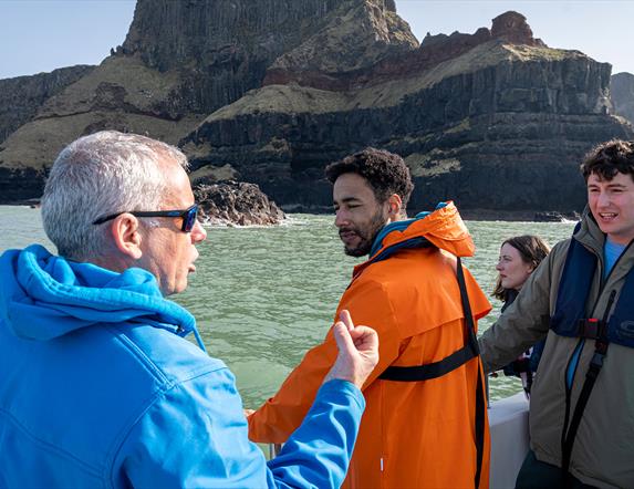 Guide/skipper of the boat talking to a group enjoying the Giant Shipwrecks of the North Coast experience