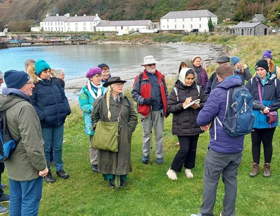 people gather outside on Rathlin Island listening to a tour guide
