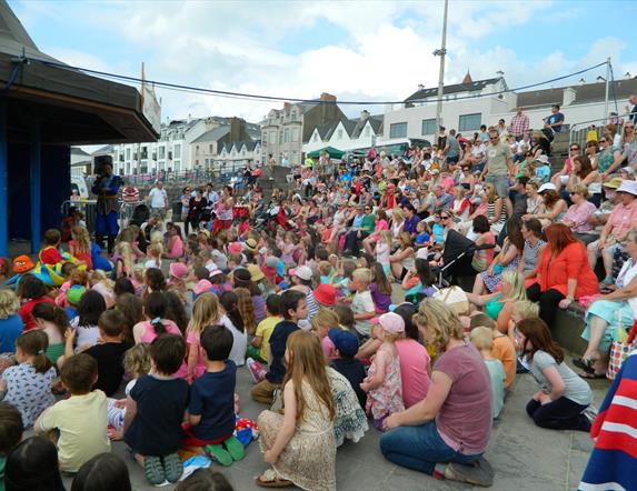 a large crowd of people watching a performance at The Crescent in Portstewart