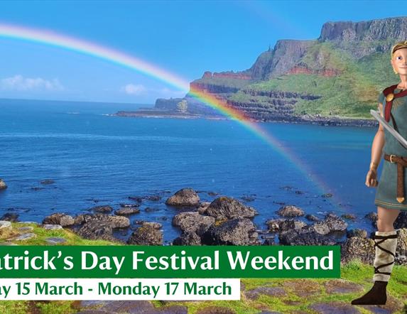 Finn McCool standing on the Grand Causeway, with a clear blue sky and double rainbow in the background and the Causeway Cliffs. Advertising a St Patri