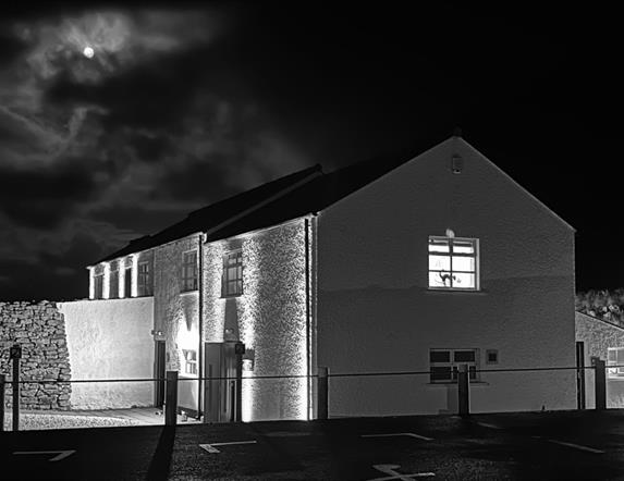 Carrick-a-Rede Tearoom at night with the moon in the background