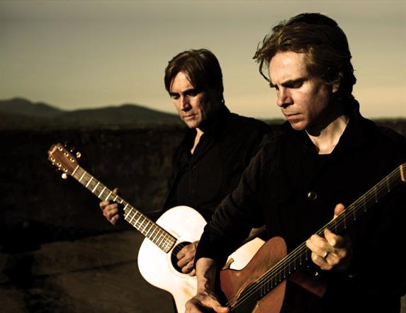 image of Brendan and Declan Murphy standing outside with guitars at dusk