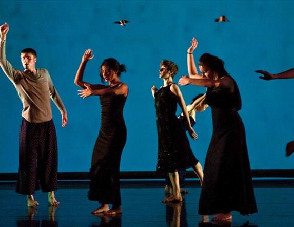 Dancers performing in front of a blue screen.