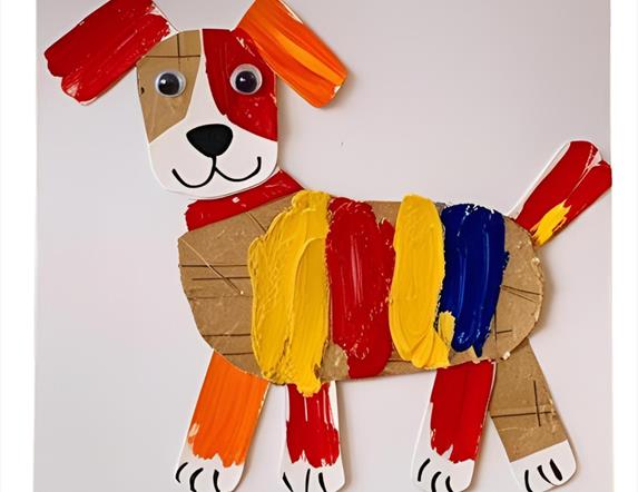 A crafted puppy make of various pieces of cardboard and other materials, painted with a range of colours.