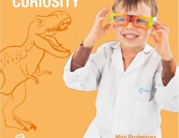 A smiling child in a white professor coat.