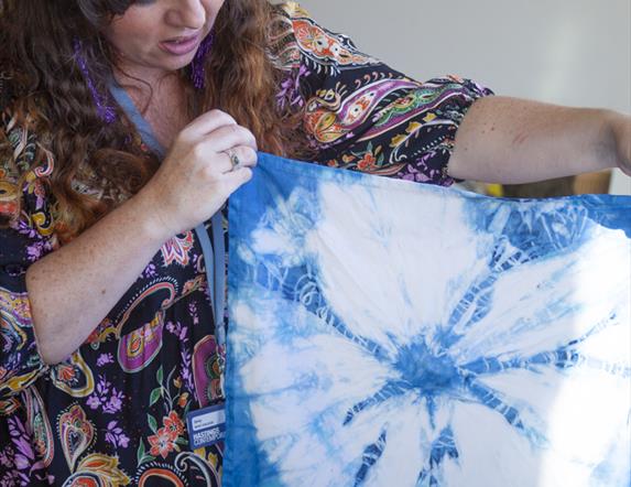 Woman holding a white and blue tie-dyed fabric.