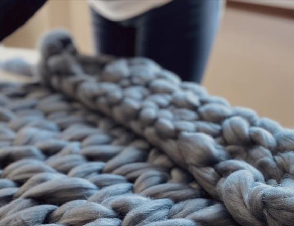 A grey, arm knitted throw