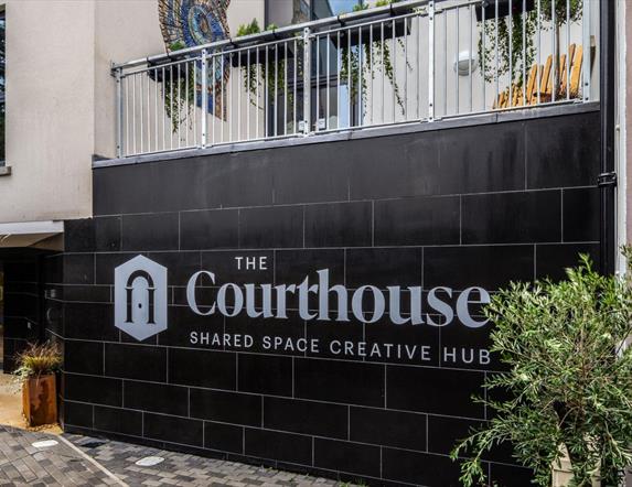 Bushmills Courthouse logo on a black tile wall.