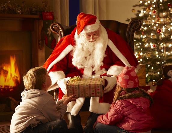 Santa claus giving a present to two children