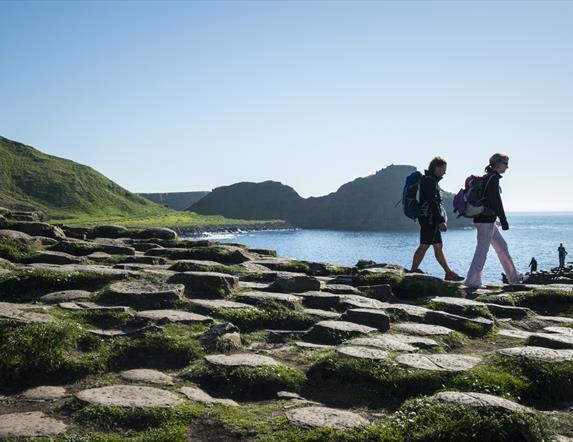 people walking across the Giant's Causeway stones