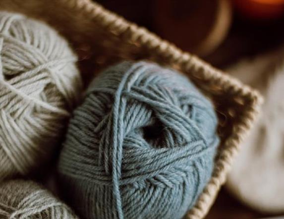 balls of wool sitting in a woven basket