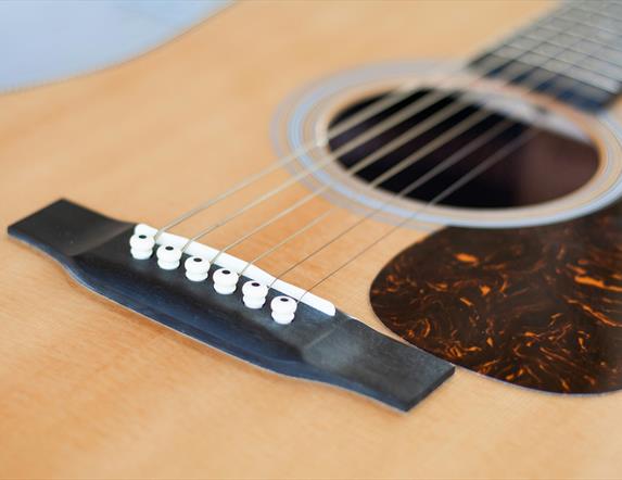 Close up photograph of an acoustic guitar